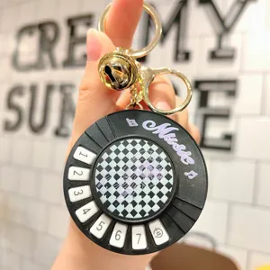 Detail shot of mini piano keychain with numbered keys and bell, decompression music toy.