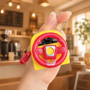 Mini simulated steering wheel keychain detail with gear shift lever and sound design.