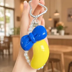 Cute fruit keychain with pearl chain and bowknot pendant, stylish bag charm accessory.