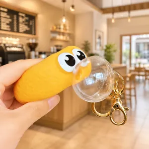Cute yellow decompression bubble blowing squeeze toy keychain with big eyes and gold hardware.