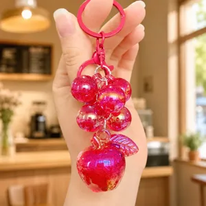 Detailed view of pink glitter bubble grape and apple keychain, stylish cute bag charm pendant.
