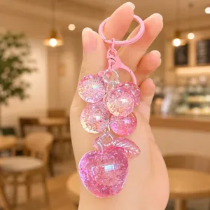 Close-up of the cute pink crystal bubble grape and apple keychain charm, showing details.