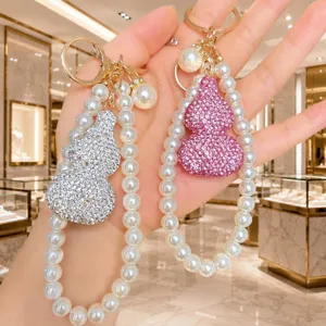 Detailansicht des edlen Strass-Kürbis-Schlüsselanhängers mit Perlen-Armband als Handyschmuck.