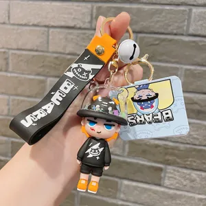 Close-up of cute cartoon PVC keychain pendant with liquid capsule and letter strap accessory.