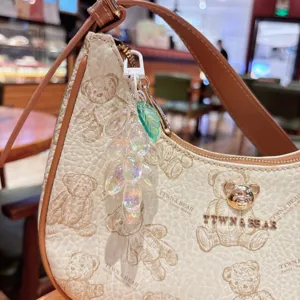 Bolso de hombro de cuero con osito y colgante de uva iridiscente en estilo coreano chic.
