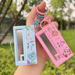 Mini electronic piano keychain toy, cute cartoon music instrument bag charm with interactive keys.