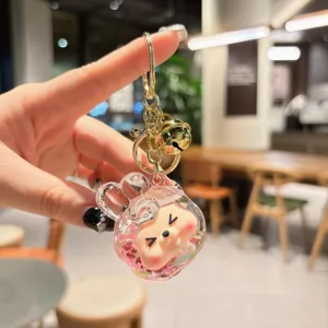 Detailed shot of cute acrylic liquid-filled keychain with gold ring for bag pendant.