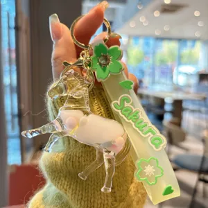 Detailaufnahme des süßen flüssigen Treibsand-Pferd-Schlüsselanhängers mit grünem Sakura-Gurt.