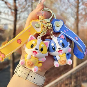 Cute cartoon dog keychain holding boba tea, soft rubber puppy charm for bag or keys detail.