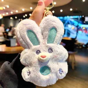 Close-up detail of the cute purple plush bunny keychain with teal ears for bags and keys.