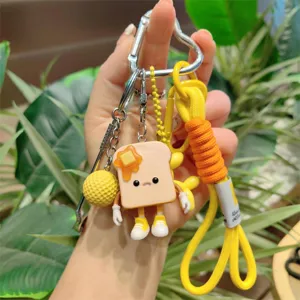 Cute toast bread keychain with braided lanyard and cartoon pendant details, close-up view.