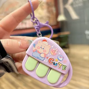 Cute music piano recorder keychain detail shot, showing the adorable cartoon bear pendant.