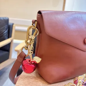 Elegante ciondolo per borsa a forma di mela rossa placcata con portachiavi a foglia d'oro.
