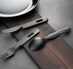 Detailed view of matte black outdoor cutlery set including knife, fork and spoon with bottle opener.