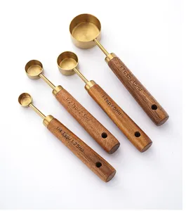 Stainless steel measuring spoons with wooden handles, detail shot of kitchen baking tool set.