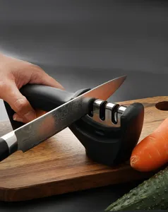Detailed view of manual kitchen knife sharpener in action on wooden cutting board.