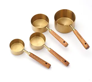 Stainless steel measuring cups detail view with wooden handles and capacity scale marks.