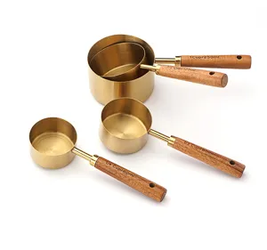 Stainless steel measuring cups set with wooden handles, golden finish kitchen baking tools.