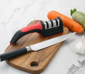 Kitchen knife sharpener detail view showcasing three sharpening slots on wooden cutting board.