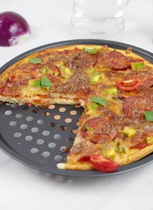 Dettaglio in primo piano di una teglia per pizza rotonda e perforata da 12 pollici in acciaio.