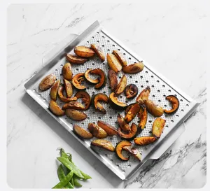 Close-up view of the square perforated barbecue grill pan featuring roasted food on top.