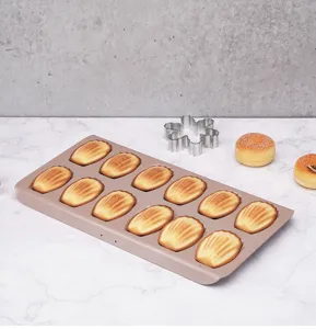Close-up detail of 12-cavity non-stick Madeleine baking mold filled with shell cakes.