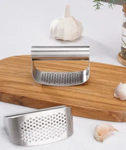 Detalle de prensa ajos de acero inoxidable con mango ergonomico y multiples orificios.