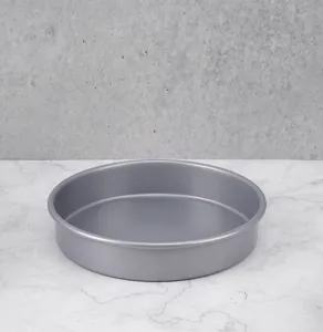 Detail shot of a round non-stick baking pan on a marble countertop, perfect for home baking use.
