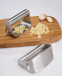 Detalle de prensa ajos de acero inoxidable con mango ergonomico y orificios de trituracion.