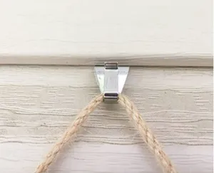 Close-up detail of stainless steel vinyl siding hook installed on wall panel with rope.