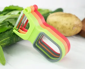 Détail éplucheur de cuisine, ensemble de trois ustensiles emnestrés pour légumes frais.