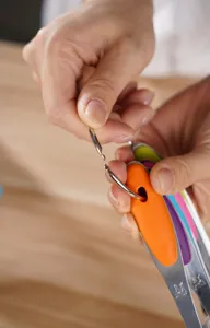 Stainless steel measuring spoon detail showing ring hook and colorful silicone handle grip.