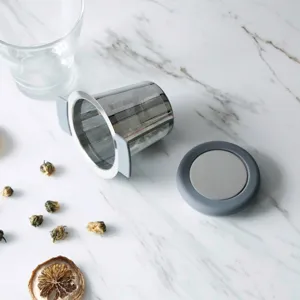 Infuseur à thé en acier inoxydable avec bord et couvercle en silicone pour tasses.