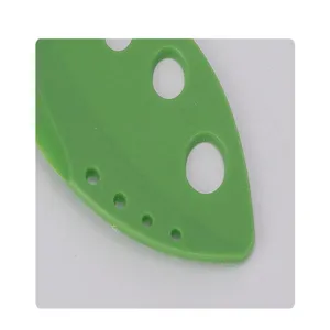 Detail shot of the green 8-hole herb stripper, perfect kitchen tool for kale and cilantro leaves.