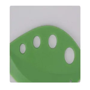 Green plastic herb stripper detail showing multiple holes for efficient leaf removal in kitchen cooking.