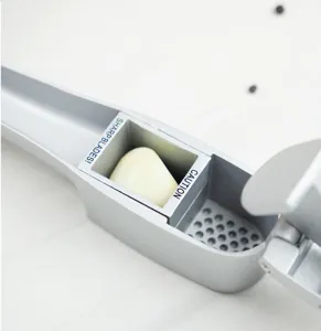 2-in-1 alloy garlic press and slicer kitchen tool with sharp blades for easy garlic preparation.