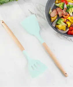 Silicone spatula detail view featuring a natural wooden handle in a kitchen cooking scene