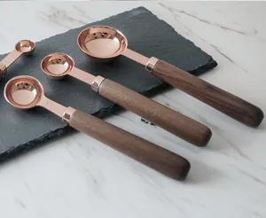 Ensemble de cuillères mesure dorées rose avec poignées en bois ustensiles de cuisine pâtisserie.
