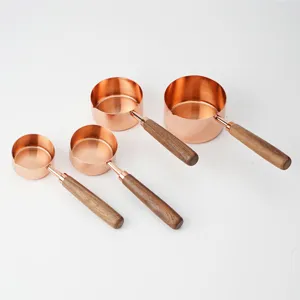 Ensemble de 4 tasses à mesurer en or rose avec poignées en bois pour la cuisine.