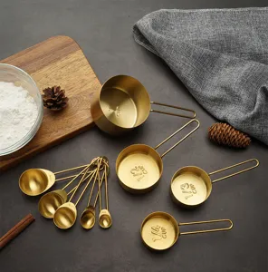 Gold stainless steel measuring cups and spoons set for baking and cooking measurement detail.
