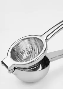 Dettaglio spremiagrumi manuale in acciaio inox con rivetto rinforzato e vaschetta.
