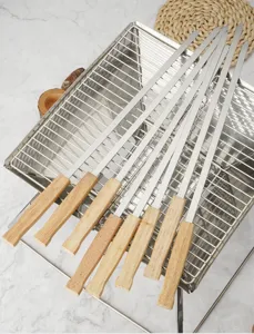 Stainless steel barbecue skewers with wooden handles, detail view of BBQ tool set for grilling.
