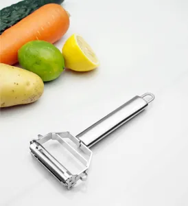 Détail d'économe double tête en acier inoxydable avec lames tranchantes et scène de légumes frais.