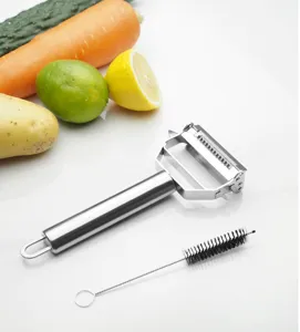 Vue détaillée de l'économe multifonction en acier inoxydable avec une brosse de nettoyage incluse.