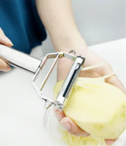 Économe à légumes en acier inoxydable et détail de l'action de râpage en cuisine pro