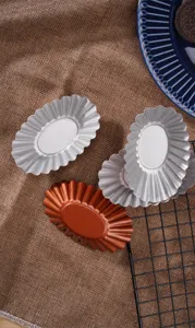Detail shot of large oval non-stick tart molds and egg tart baking pans in silver and champagne.