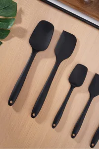 Vista detallada del juego de espátulas de silicona negra para repostería con orificio.