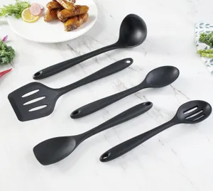 Detail view of 5-piece black silicone kitchen utensil set with spatula and spoon on marble.