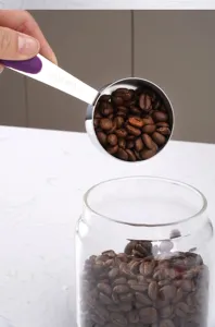 Stainless steel measuring spoon with scale for coffee and baking, durable kitchen tool.