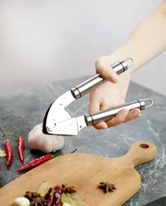 Stainless steel garlic press detail showcasing manual crushing tool operation in kitchen.